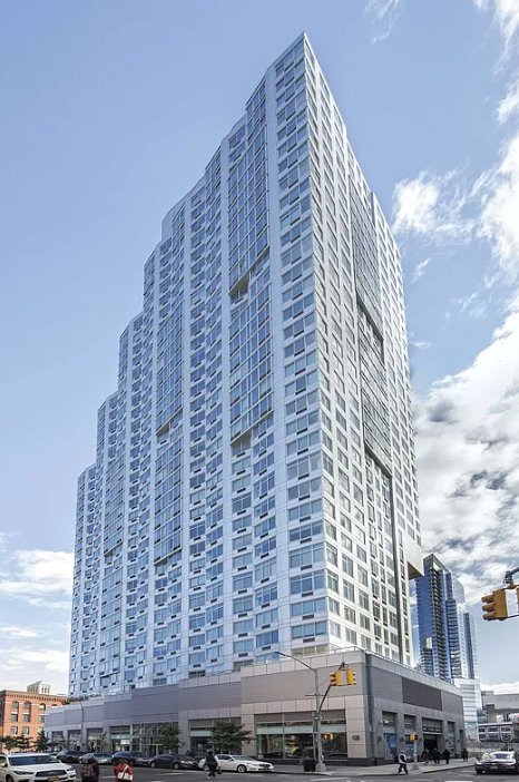 a tall building with many windows and a street in front of it